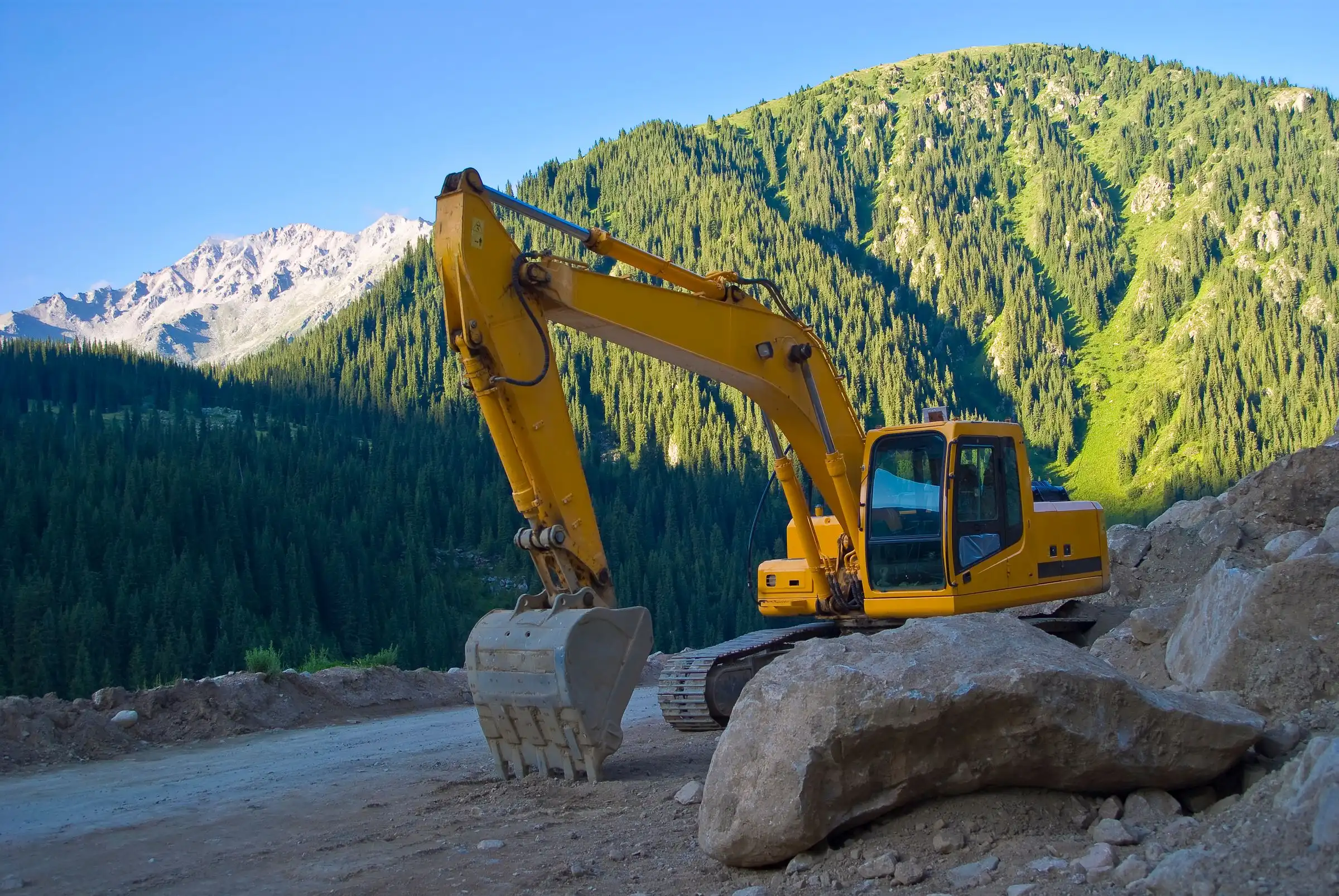 Excavadora trabajando en un camino de montaña